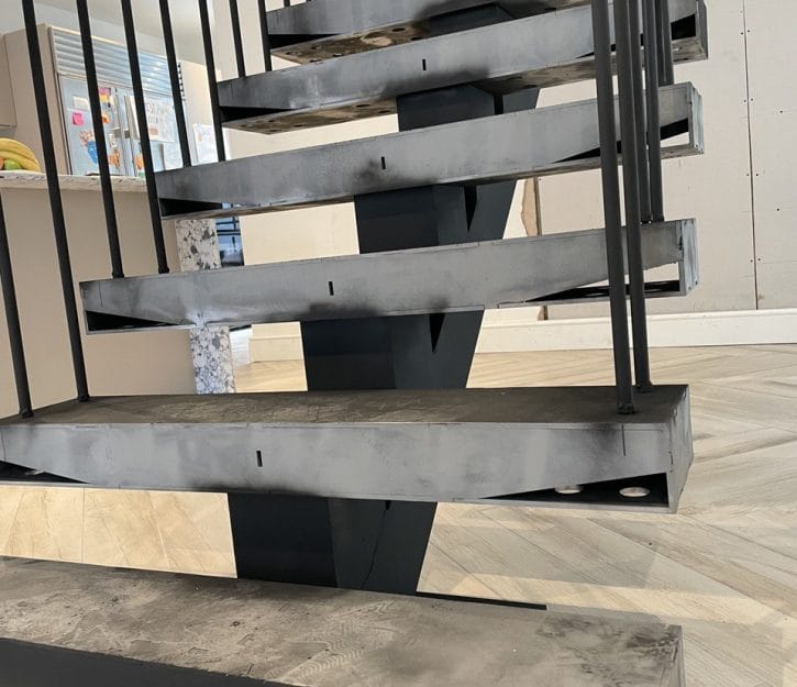 Discover the elegance of our custom-designed spine staircase, featuring sleek metal rod balustrades, meticulously created by V.P Stairs Ltd for contemporary, upscale spaces.