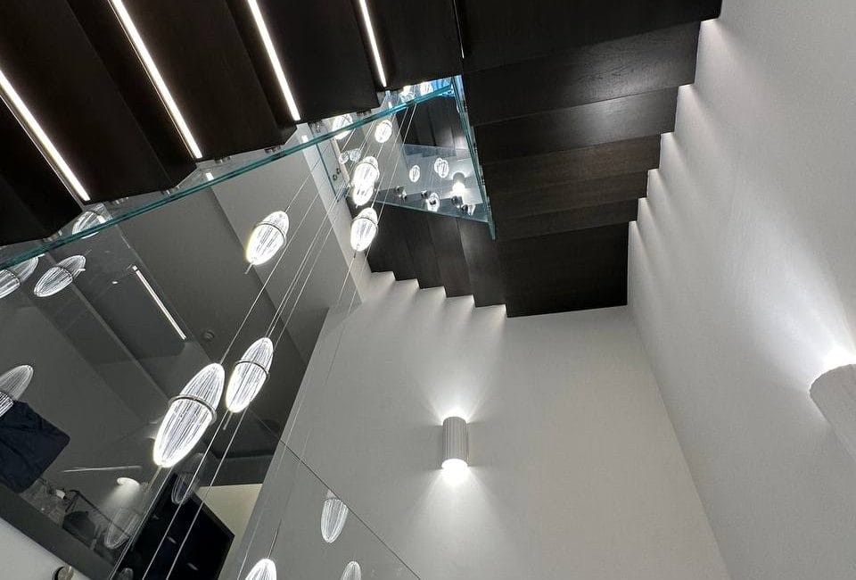 Elevate your space with V.P Stairs Ltd's chic combination of glass balustrades and luxurious black wooden stairs, perfect for contemporary interiors.