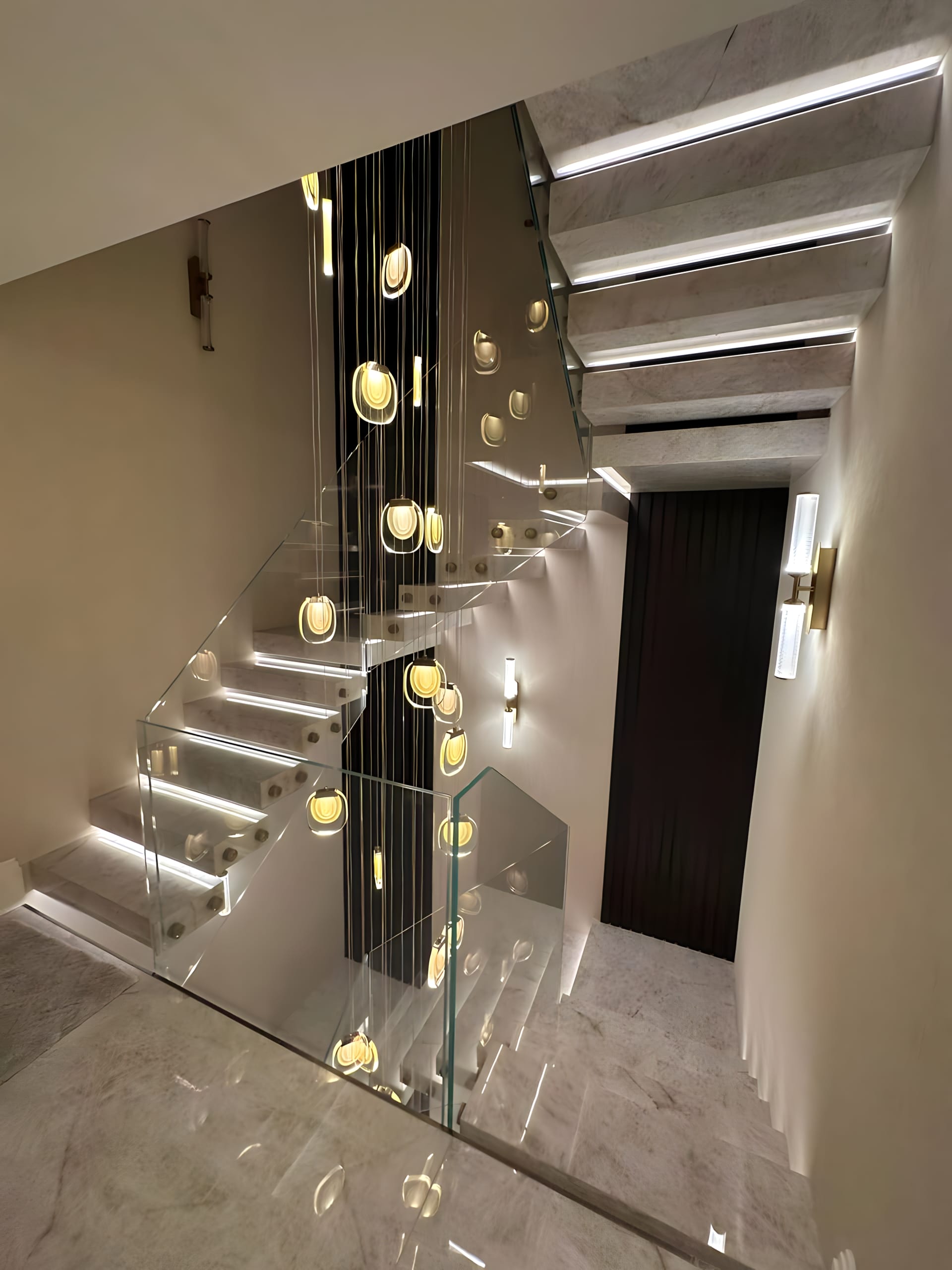 Luxurious marble stairs paired with sleek glass panel balustrades, expertly crafted to enhance any upscale architectural space.