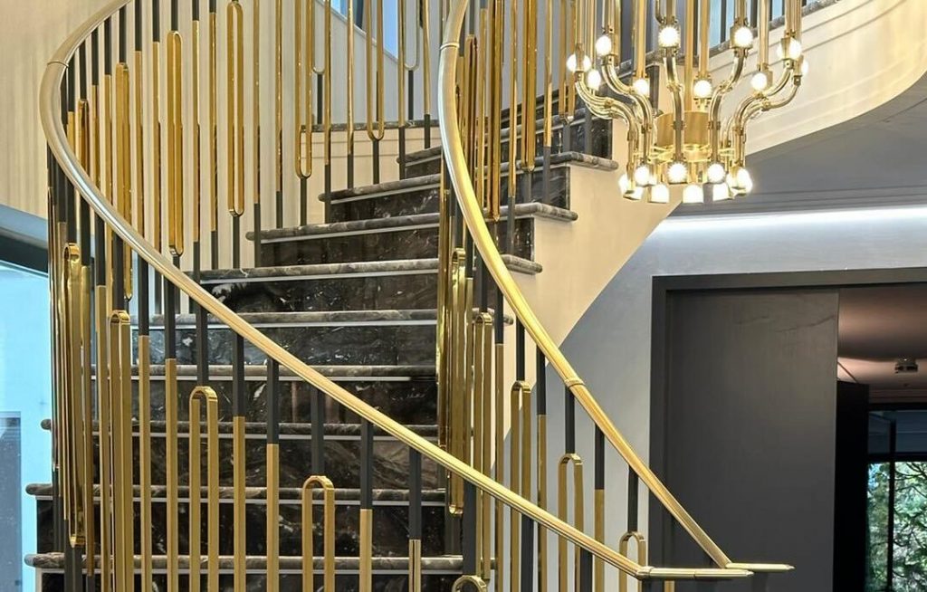 Custom staircase combining natural stone, glass, and aluminium in modern interior