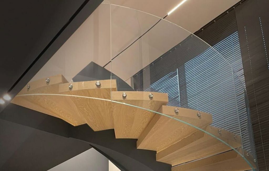 Futuristic glass staircase with metal frame and panoramic lighting in a modern interior
