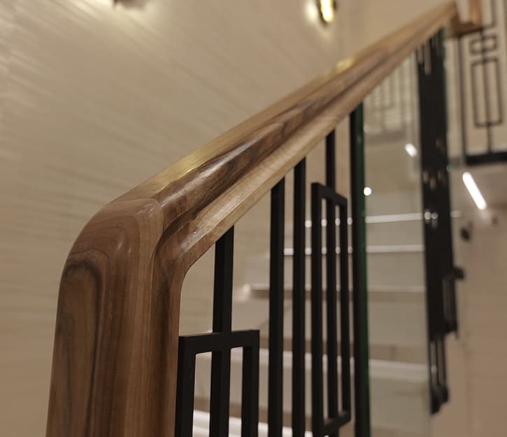 Walnut handrail with seamless curved joint — bespoke staircase craftsmanship by V.PSTAIRS
