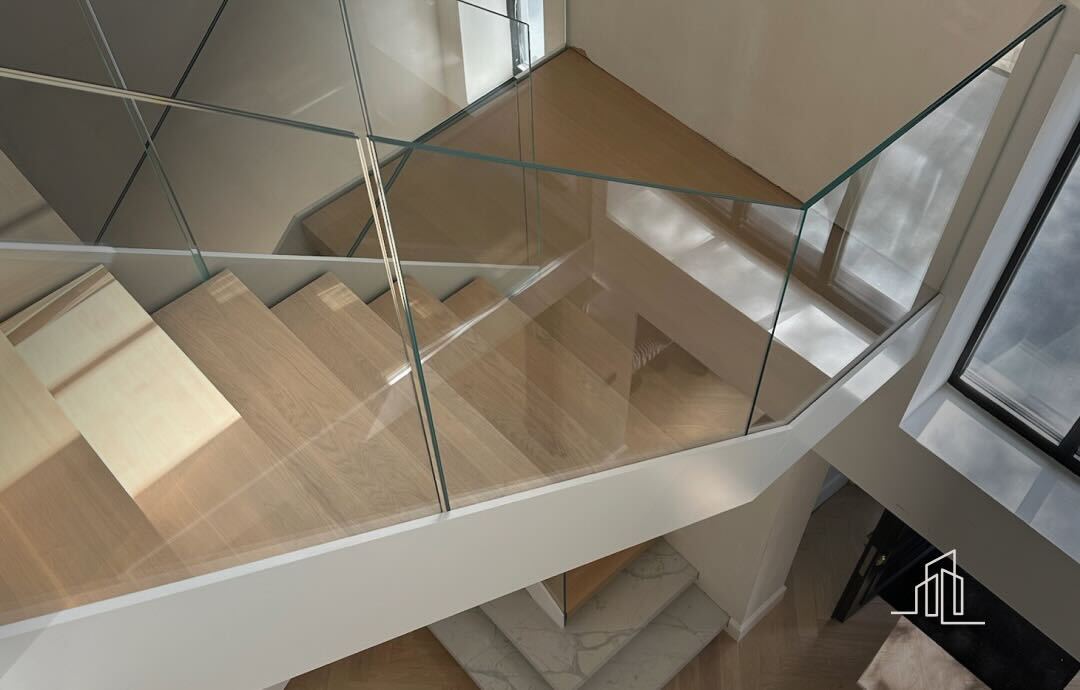 A sophisticated staircase with a glass balustrade