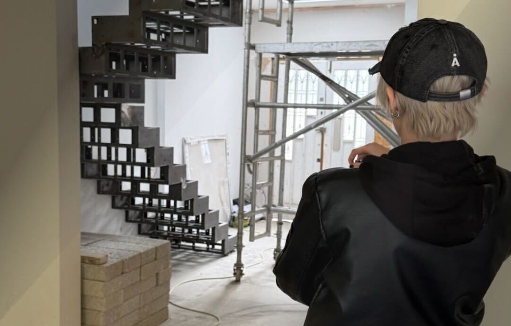 A person looking at the installation of a staircase on an object