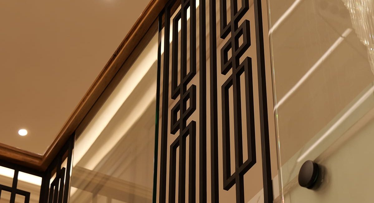 Custom geometric metal and glass balustrade with walnut handrail by V.PSTAIRS
